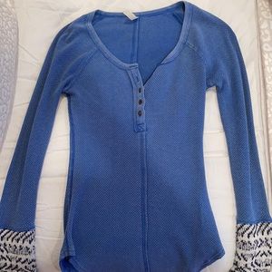 A blue waffle free people shirt with design on the bottom of the sleeves!